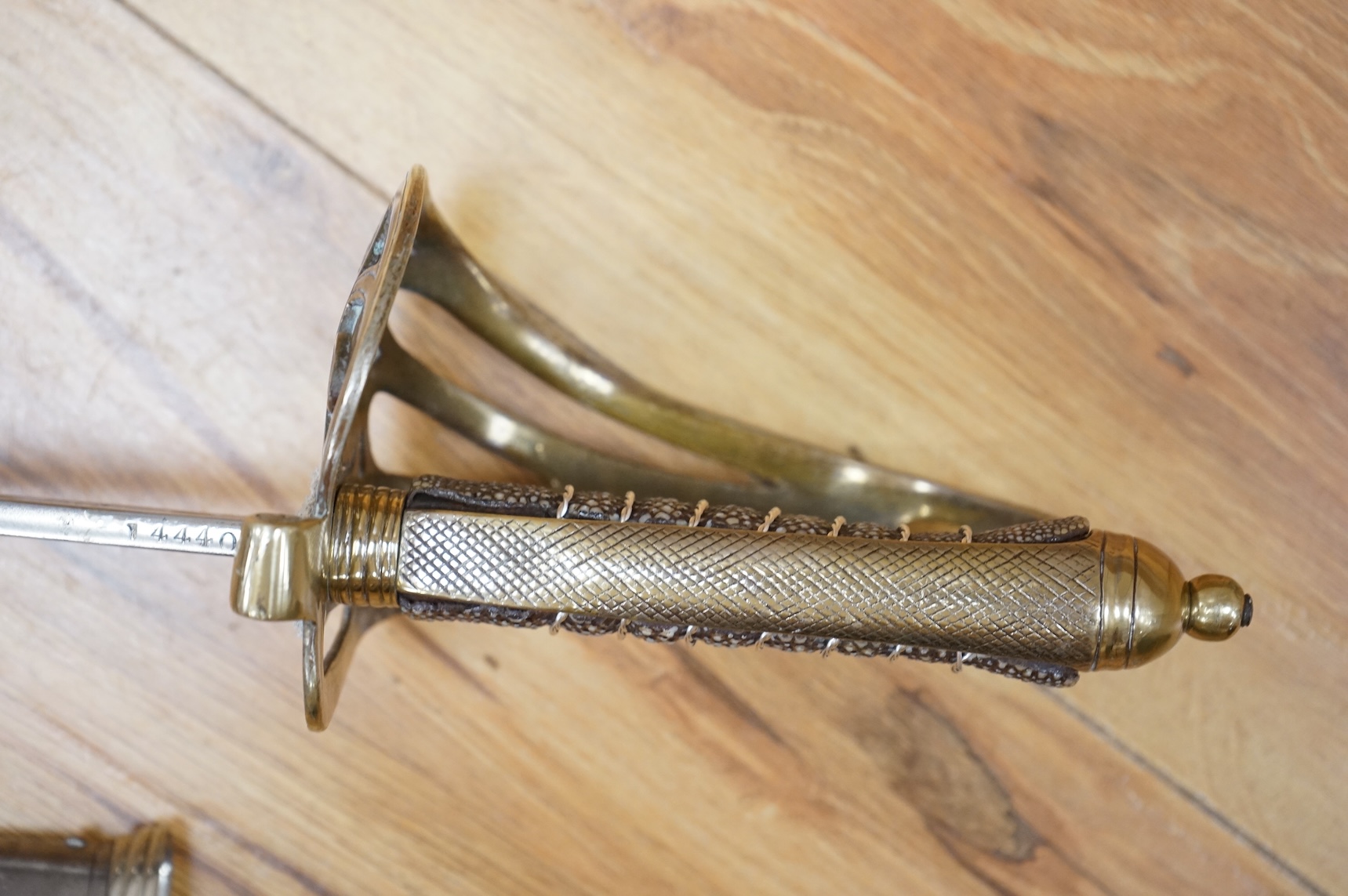 A post 1902, 1827 pattern Rifle Brigade officer’s dress sword, with regulation blade with traces of edge decoration, regulation nickel guard with crown strung bugle and wire bound fish skin covered grip, in its steel sca